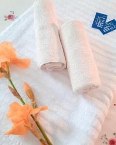 two rolls of towels on a white towel with flowers at Holiday Home CASTLE in Bihać +46 photos