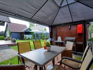 een tafel en stoelen onder een parasol op een patio bij Blisko morza in Jastarnia