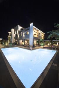 a large swimming pool in front of a house at night at Villa Irina sea view in Sykia Chalkidikis
