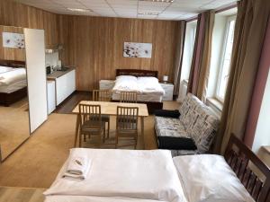 Zimmer mit 2 Betten, einem Tisch und Stühlen in der Unterkunft DNM Inn in Koryčany