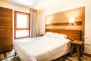 a hotel room with a bed and a window at Large one-bedroom apartment, wheelchair adapted, Les Terrasses d'Eos in Flaine