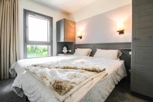 um quarto com uma cama grande e uma janela em South-facing newly renovated 2-bed apartment Les Terrasses d'Eos em Flaine