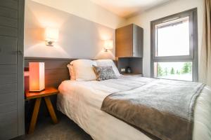 a bedroom with a large bed and a window at South-facing newly renovated 2-bed apartment Les Terrasses d'Eos in Flaine +56 photos