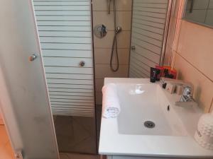 a bathroom with a white sink and a shower at Viktoria in Eilat