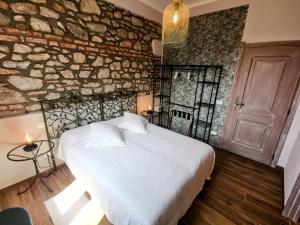 - une chambre avec un lit et un mur en pierre dans l'établissement La Luna dei Medici, à Fivizzano