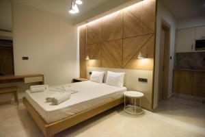 um quarto com uma grande cama branca e um banco em Villa Ikaros em Ammoudia