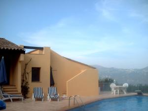 una piscina con sillas, una mesa y una casa en Maison d'hôtes Escale d'Azur, en Gattières