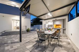 a dining room with a table and chairs on a patio at Villa Amaris in Brodarica