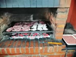 a brick oven with a bunch of meat in it at Casa Sofia Dorna Candrenilor in Dorna Cîndrenilor