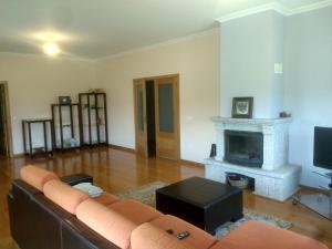 een woonkamer met een bank en een open haard bij Casa do Carvalho in Ribeira de Pena