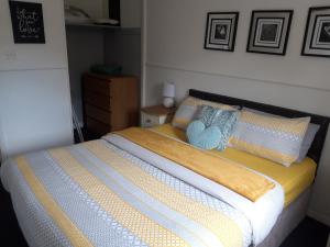 a bedroom with a bed with a blue blanket and pillows at Hardgate Gardens in Glasgow