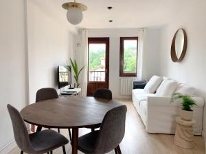 sala de estar con mesa y sofá en ACOGEDOR APARTAMENTO CON TERRAZA Y PARKING Publico EN COMILLAS, en Comillas