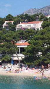 a group of people laying on a beach at Villa Bose- Apartmani Luka Šodan in Brela