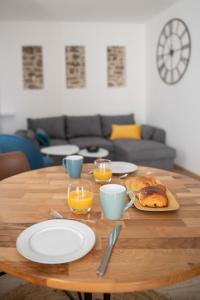 una mesa de madera con platos de comida y vasos de zumo de naranja en CUDJOE, en Dinan