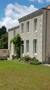 una casa con un patio de hierba delante de ella en La Marsaisienne, en Marsais