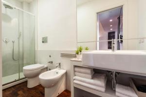 a white bathroom with a sink and a toilet at Ferrini Home - Via Monte Sant'Agata in Catania