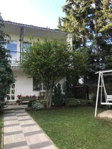 une maison avec un arbre et une balançoire dans la cour dans l'établissement Bartalos ház, à Zánka