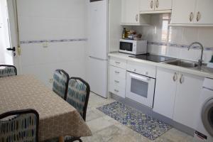 a kitchen with a table and a sink and a microwave at Apartamento Vistas molineras in Consuegra