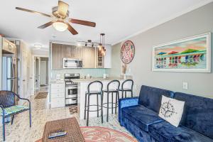a living room with a blue couch and a kitchen at Sea Cabin 342-C in Isle of Palms