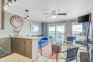 a kitchen and living room with a ceiling fan at Sea Cabin 342-C in Isle of Palms