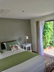 a bedroom with a large bed with a window at Cherrybrook in Glastonbury