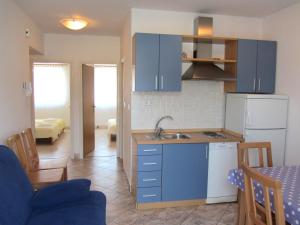 a kitchen with blue cabinets and a sink in a room at Apartments Luna in Tisno