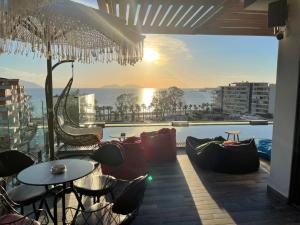 a patio with tables and chairs and a view of the ocean at Ames Hotel & SPA in Vlorë
