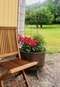 un banco de madera junto a una maceta de flores en Villa Syren, en Söderköping