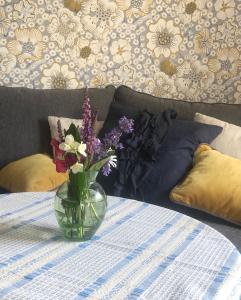 un jarrón de flores sentado en una mesa en Villa Syren en Söderköping