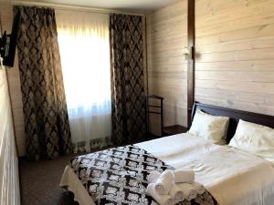 1 dormitorio con 1 cama con sábanas blancas y ventana en Олівія en Skhidnitsa