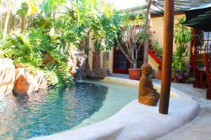 eine Statue neben einem Pool in einem Resort in der Unterkunft Goblin's Mead in Edgemead