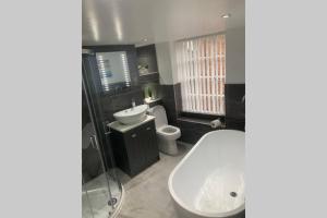 a bathroom with a tub and a sink and a toilet at Hexham Town Centre, Market Place View in Hexham