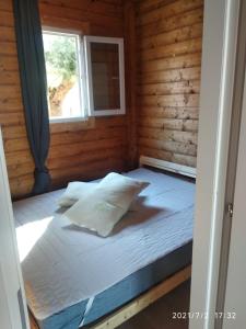 Cama en habitación de madera con ventana en Camping Borghetti, en Ortona
