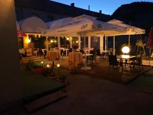 una terraza de madera con mesas, sillas y sombrillas en Hotel Reinisch, en Köflach