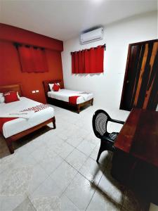 シウダード・デル・カルメンにあるHotel Costa Mariaのベッド2台とデスクが備わる客室です。