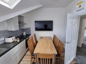 a kitchen with a wooden table and chairs at Granada Apartments at Pleasure Beach in Blackpool