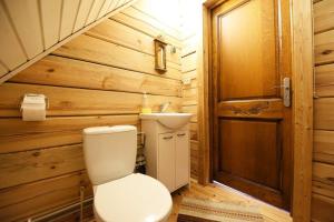 a bathroom with a toilet and a wooden wall at Judbidzi in Pape