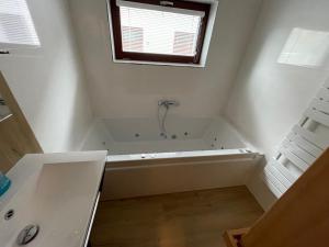 bagno bianco con vasca e finestra di Resort Nová Pec a Nová Pec Altre 11 foto