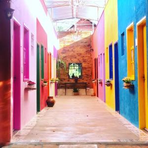 um corredor de edifícios coloridos com um banco ao longe em Villa da Serra Pousada em Piuí