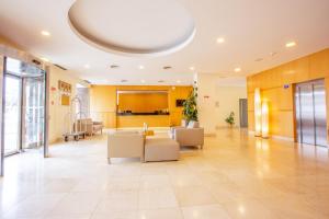 a lobby with a couch and chairs in a building at MS Vila Nova in Ponta Delgada