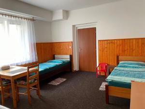 a room with two beds and a table and a table and chairs at Garsoniera v roddiném domě in Dubice