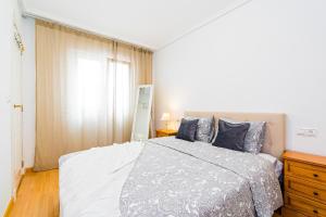 um quarto com uma cama grande e uma janela em Apartment Natalia em Torrevieja