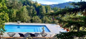 a swimming pool with chairs and a view of a mountain at Casa Stella Country House in Savigno