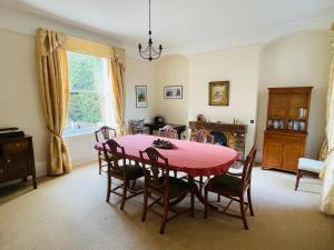 a dining room with a pink table and chairs at Croxton House in Kirmington