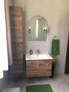 Lovas Vendégház في تيسزافوريد: حمام مع حوض ومرآة