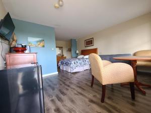 a room with a bedroom with a bed and a table at Bouctouche Bay Inn in Bouctouche