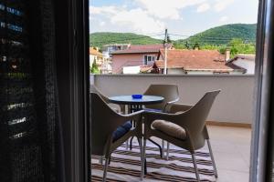 balcón con mesa, sillas y ventana en Apartman N&P en Soko Banja