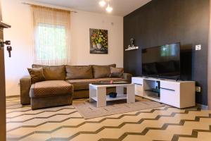 a living room with a couch and a flat screen tv at Apartman N&P in Soko Banja