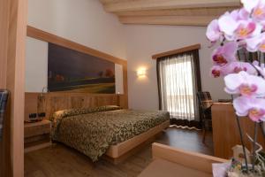 a bedroom with a bed and a large painting on the wall at Hotel Alpino in Varena