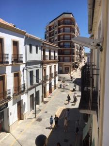eine Gruppe von Menschen, die eine Straße mit Gebäuden entlang gehen in der Unterkunft Apartamentos Acevedo Centro I in Ronda